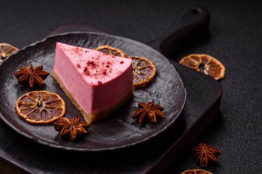 Ahududu ya da çilek aromalı, koyu beton arka planda maskaron peynirli tatlı bir cheesecake.