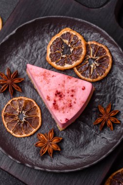 Ahududu ya da çilek aromalı, koyu beton arka planda maskaron peynirli tatlı bir cheesecake.