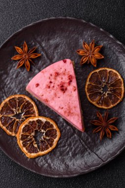 Ahududu ya da çilek aromalı, koyu beton arka planda maskaron peynirli tatlı bir cheesecake.