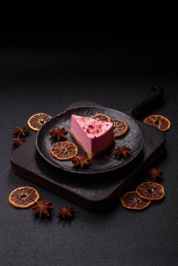Ahududu ya da çilek aromalı, koyu beton arka planda maskaron peynirli tatlı bir cheesecake.