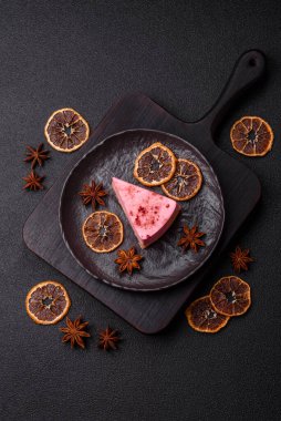 Ahududu ya da çilek aromalı, koyu beton arka planda maskaron peynirli tatlı bir cheesecake.