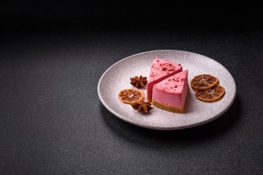 Ahududu ya da çilek aromalı, koyu beton arka planda maskaron peynirli tatlı bir cheesecake.