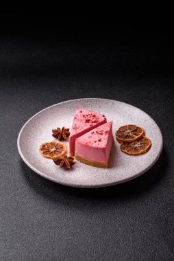 Ahududu ya da çilek aromalı, koyu beton arka planda maskaron peynirli tatlı bir cheesecake.
