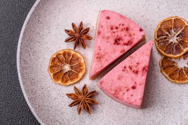 Ahududu ya da çilek aromalı, koyu beton arka planda maskaron peynirli tatlı bir cheesecake.