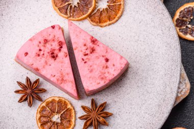 Ahududu ya da çilek aromalı, koyu beton arka planda maskaron peynirli tatlı bir cheesecake.