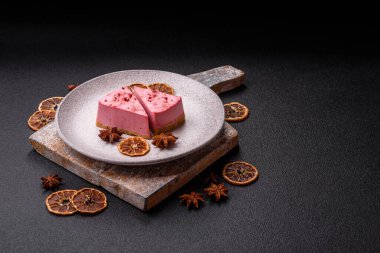 Ahududu ya da çilek aromalı, koyu beton arka planda maskaron peynirli tatlı bir cheesecake.