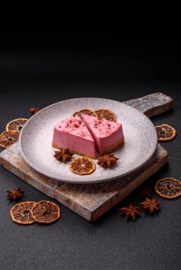 Ahududu ya da çilek aromalı, koyu beton arka planda maskaron peynirli tatlı bir cheesecake.