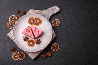 Ahududu ya da çilek aromalı, koyu beton arka planda maskaron peynirli tatlı bir cheesecake.