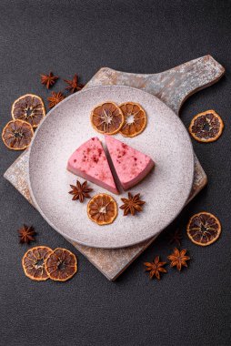 Ahududu ya da çilek aromalı, koyu beton arka planda maskaron peynirli tatlı bir cheesecake.