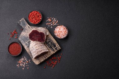 Esmer arka planda tuz, baharat ve otlarla tütsülenmiş at eti.