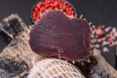 Esmer arka planda tuz, baharat ve otlarla tütsülenmiş at eti.