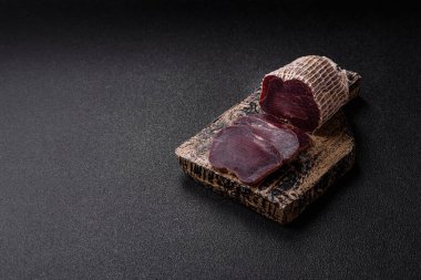 Esmer arka planda tuz, baharat ve otlarla tütsülenmiş at eti.