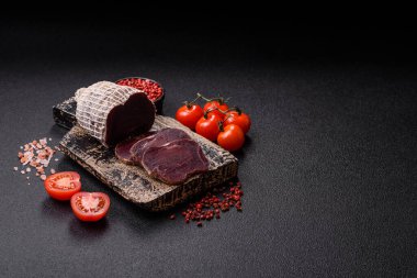 Esmer arka planda tuz, baharat ve otlarla tütsülenmiş at eti.