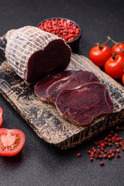 Esmer arka planda tuz, baharat ve otlarla tütsülenmiş at eti.