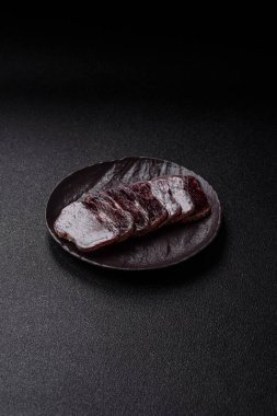 Esmer arka planda tuz, baharat ve otlarla tütsülenmiş at eti.