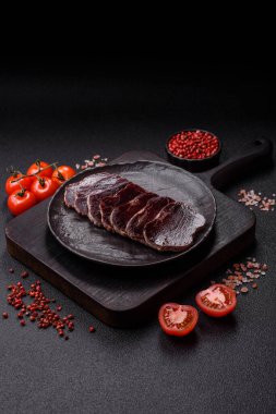 Esmer arka planda tuz, baharat ve otlarla tütsülenmiş at eti.