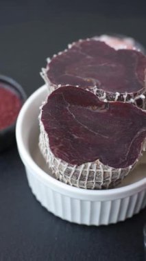 Esmer arka planda tuz, baharat ve otlarla tütsülenmiş at eti.