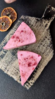 Ahududu ya da çilek aromalı, koyu beton arka planda maskaron peynirli tatlı bir cheesecake.