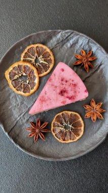 Ahududu ya da çilek aromalı, koyu beton arka planda maskaron peynirli tatlı bir cheesecake.