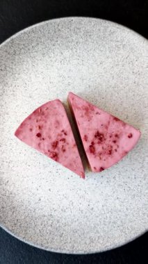 Ahududu ya da çilek aromalı, koyu beton arka planda maskaron peynirli tatlı bir cheesecake.