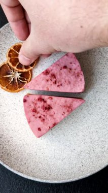 Ahududu ya da çilek aromalı, koyu beton arka planda maskaron peynirli tatlı bir cheesecake.