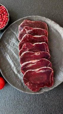 Esmer arka planda tuz, baharat ve otlarla tütsülenmiş at eti.