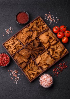 Tohumlar, tanecikler, tuz, baharatlar ve çimento kaplı ev yapımı çıtır kahverengi ekmek cipsleri.