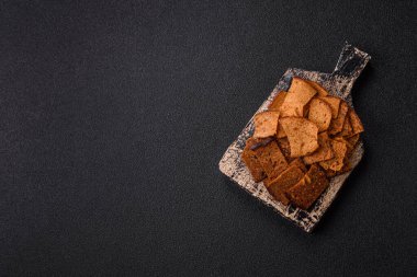 Tohumlar, tanecikler, tuz, baharatlar ve çimento kaplı ev yapımı çıtır kahverengi ekmek cipsleri.