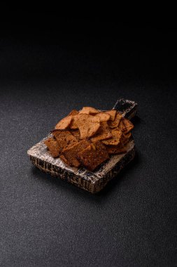 Tohumlar, tanecikler, tuz, baharatlar ve çimento kaplı ev yapımı çıtır kahverengi ekmek cipsleri.