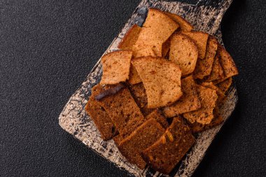 Tohumlar, tanecikler, tuz, baharatlar ve çimento kaplı ev yapımı çıtır kahverengi ekmek cipsleri.