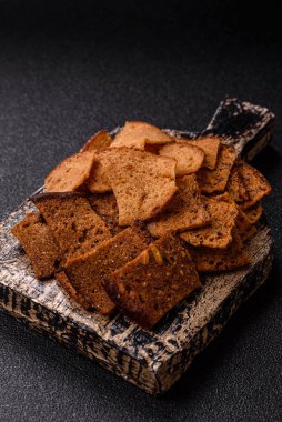 Tohumlar, tanecikler, tuz, baharatlar ve çimento kaplı ev yapımı çıtır kahverengi ekmek cipsleri.