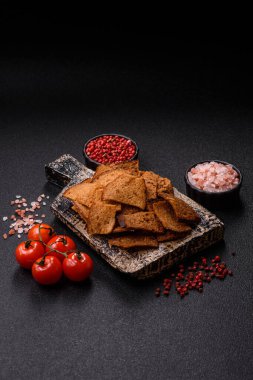 Tohumlar, tanecikler, tuz, baharatlar ve çimento kaplı ev yapımı çıtır kahverengi ekmek cipsleri.