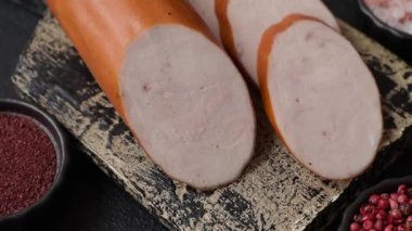 Lezzetli haşlanmış tavuk ya da koyu beton arka planda dilimlenmiş domuz sosisi.