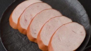 Lezzetli haşlanmış tavuk ya da koyu beton arka planda dilimlenmiş domuz sosisi.