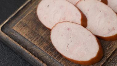 Lezzetli haşlanmış tavuk ya da koyu beton arka planda dilimlenmiş domuz sosisi.