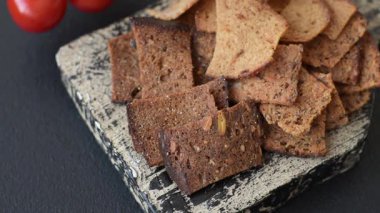 Tohumlar, tanecikler, tuz, baharatlar ve çimento kaplı ev yapımı çıtır kahverengi ekmek cipsleri.