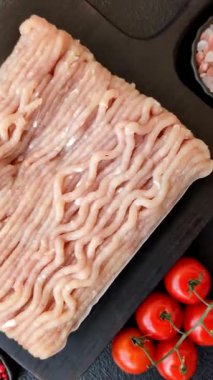 Koyu beton arka planda tuzlu, baharatlı ve otlu çiğ tavuk.