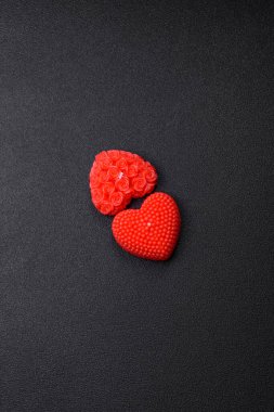 Koyu beton bir zeminde Sevgililer Günü için dekorasyon olarak kalp şeklinde kırmızı mum.