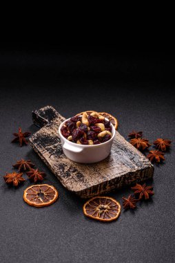 Koyu beton arka planda kavrulmuş kaju ve kurutulmuş kızılcık karışımı.