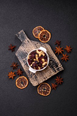 Koyu beton arka planda kavrulmuş kaju ve kurutulmuş kızılcık karışımı.