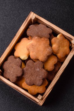 Koyu beton arka planda sarı ve kahverengi renkli zencefilli kurabiyeler.