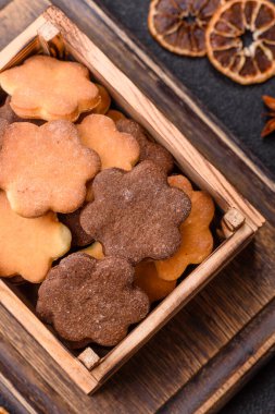 Koyu beton arka planda sarı ve kahverengi renkli zencefilli kurabiyeler.