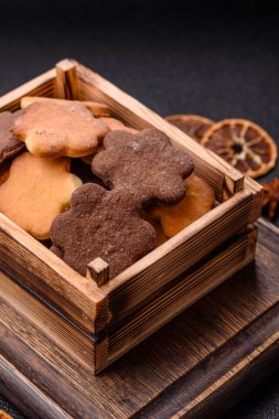 Koyu beton arka planda sarı ve kahverengi renkli zencefilli kurabiyeler.