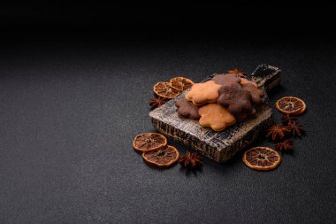 Koyu beton arka planda sarı ve kahverengi renkli zencefilli kurabiyeler.