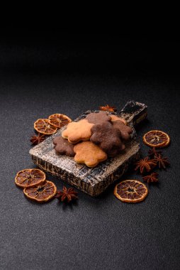 Koyu beton arka planda sarı ve kahverengi renkli zencefilli kurabiyeler.