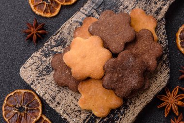 Koyu beton arka planda sarı ve kahverengi renkli zencefilli kurabiyeler.