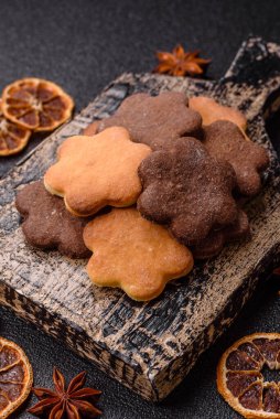 Koyu beton arka planda sarı ve kahverengi renkli zencefilli kurabiyeler.