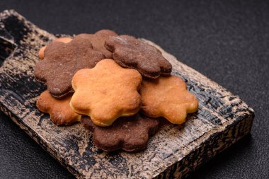 Koyu beton arka planda sarı ve kahverengi renkli zencefilli kurabiyeler.