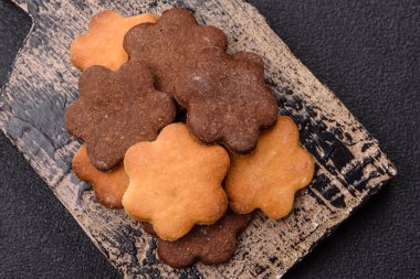 Koyu beton arka planda sarı ve kahverengi renkli zencefilli kurabiyeler.