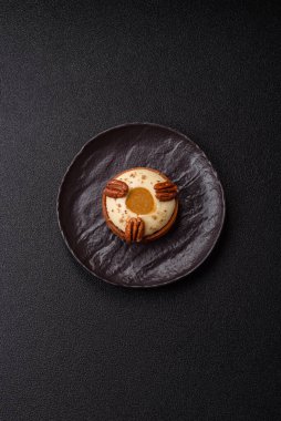 Beyaz narenciye kremalı ve fındıklı, koyu beton kaplamalı tatlı turta.